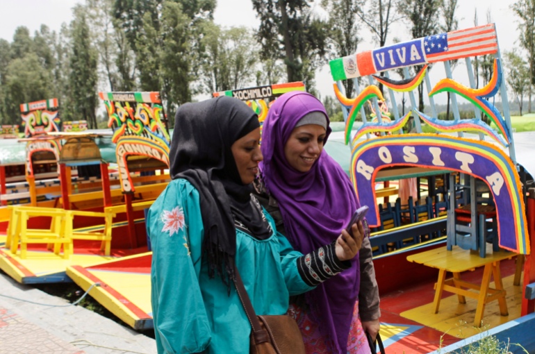 نساء مسلمات يمشين بجوار trajineras (القوارب) في قنوات Xochimilco أثناء احتفالهن بالعيد في مكسيكو سيتي 