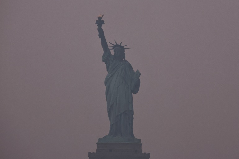 The Statue of Liberty is covered by haze and smoke caused by wildfires in Canada, in New York