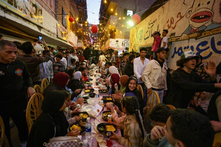 Egyptian residents of Ezbet Hamada in Cairo's Mataria district gather to eat Iftar, the meal to end their fast at sunset, during the holy fasting month of Ramadan in Cairo, Egypt March 15, 2025. REUTERS/Mohamed Abd El Ghany