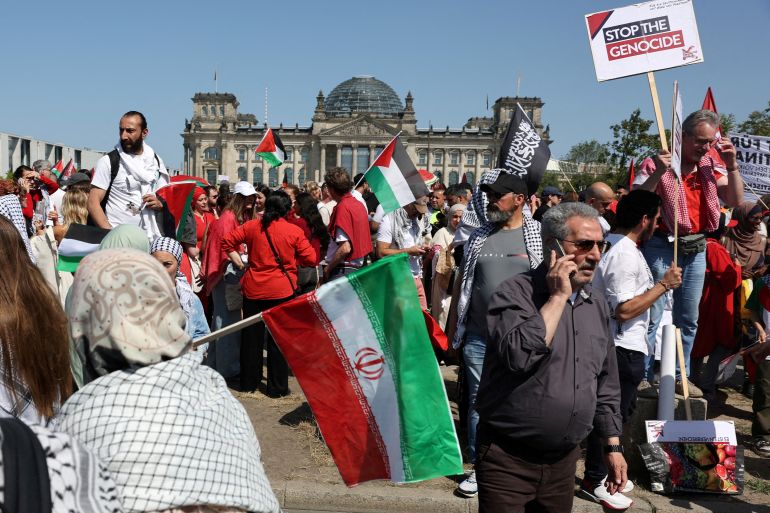 A demonstrator holds an Iranian national flag during a protest against conditions in Gaza and to impose sanctions against Israel and against arms shipments in front of the Reichstag building, the seat of the lower house of parliament Bundestag, in Berlin, Germany, June 21, 2025. REUTERS/Fabrizio Bensch TPX IMAGES OF THE DAY