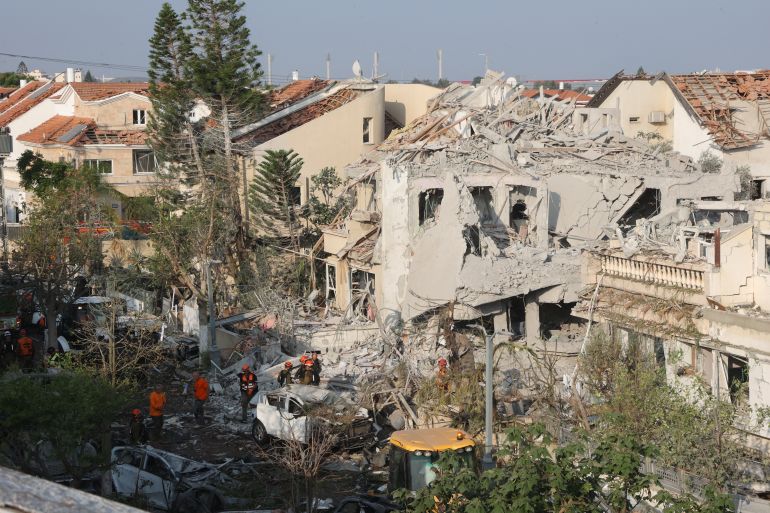 Israeli emergency responders inspect a site hit by a missile fired from Iran near Tel Aviv on June 14, 2025.