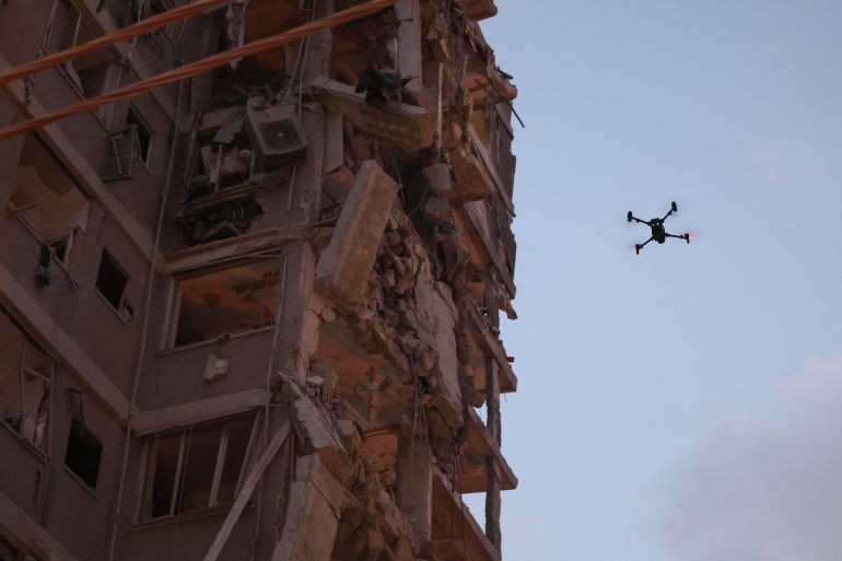 A drone flies beside a damaged building following a strike by an Iranian missile in the Israeli city of Bat Yam, south of Tel Aviv, early on June 15, 2025.