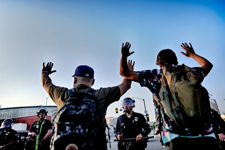 Los Angeles police officers with batons and riot gear attempt to move back protesters in downtown Los Angeles on Monday, June 9, 2025. (AP Photo/Eric Thayer)
