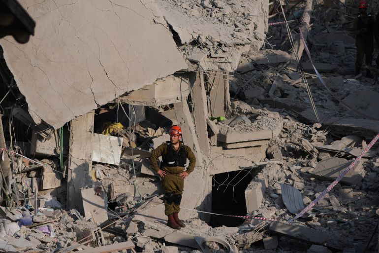 Israeli security forces inspect destroyed houses that were struck by a missile fired from Iran, in Rishon Lezion, Israel on Saturday, June 14, 2025. (AP Photo/Ohad Zwigenberg)