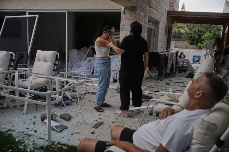 Residents react after their home was struck by a missile launched from Iran, in Rishon Lezion, Israel, on Saturday, June 14, 2025. (AP Photo/Ohad Zwigenberg)