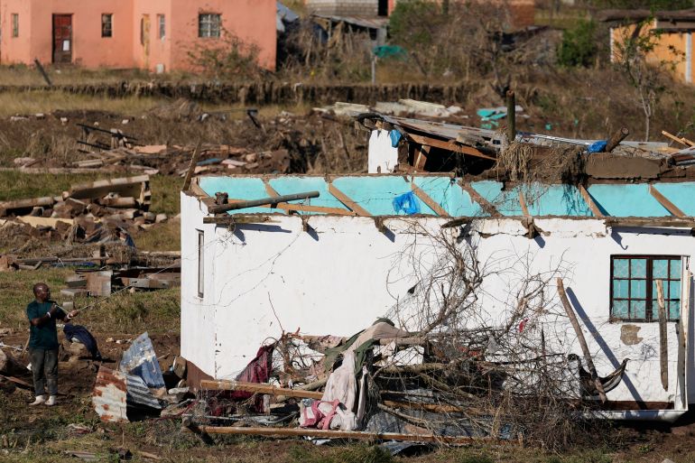 A man salvages belongings from his flood-damaged house in Mthatha, South Africa, Friday, June 13, 2025. (AP Photo/Themba Hadebe)