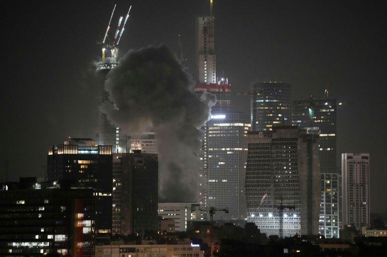 Smoke billows after a projectile hit a building in Tel Aviv, Israel, early Saturday, June 14, 2025. (AP Photo/Leo Correa)