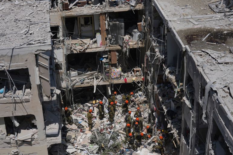 Israeli soldiers dig through rubble to search for survivors in a residential area hit by a missile fired from Iran, in Bat Yam, central Israel, Sunday, June 15, 2025.(AP Photo/Ariel Schalit)