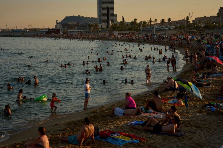 Swimmers cool off in the water at a beach on a hot day in Barcelona, Spain, Sunday, June 29, 2025. (AP Photo/Emilio Morenatti)