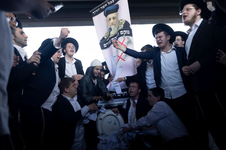 BNEI BRAK, ISRAEL - JUNE 5: Ultra Orthodox Jewish men throw conscription orders into an installation of a toilet as they block a main highway during a demonstration against drafting to the Israeli army on June 5, 2025 in Bnei Brak, Israel. Haredi men of military age have so far been able to avoid the draft by enrolling for study in yeshivas and obtaining one-year service deferrals that repeat until they reach the age of military exemption. The law, which created this exemption, expired in June 2023, and the temporary regulations to extend it have come to an end. Following the government's failure to pass legislation exempting students from military service, Israel's two ultra-Orthodox parties are now discussing withdrawing from the coalition. (Photo by Amir Levy/Getty Images)