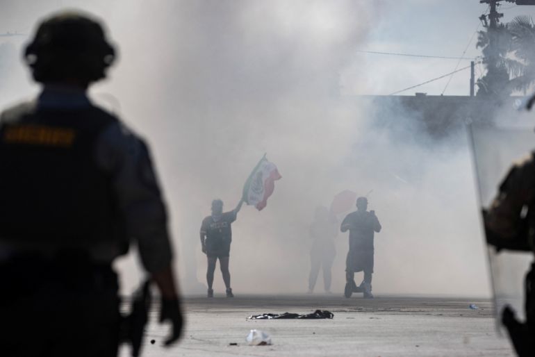 Protesters are blanketed in smoke along Alondra Boulevard during a standoff with law enforcement following multiple detentions by Immigration and Customs Enforcement (ICE), in the Los Angeles County city of Paramount, California, U.S., June 7, 2025. REUTERS/Barbara Davidson