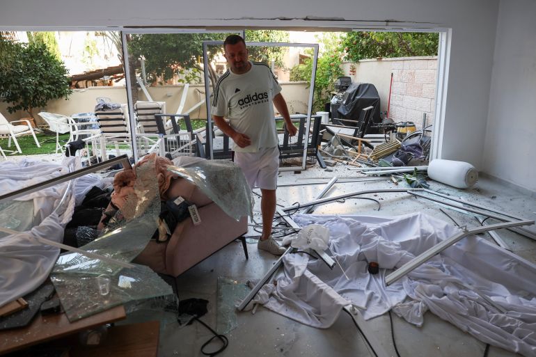 A man walks inside a damaged house at an impact site following missile attack from Iran on Israel, in Rishon LeZion, Israel, June 14, 2025. REUTERS/Ronen Zvulun