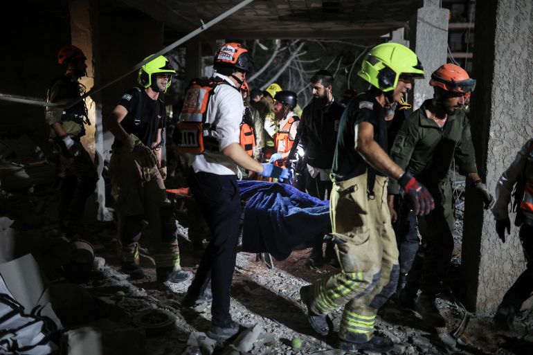 Rescue and security personnel carry a wounded person at an impact site following missile attack from Iran on Israel, in Ramat Gan, Israel June 13, 2025 REUTERS/Itai Ron ISRAEL OUT. NO COMMERCIAL OR EDITORIAL SALES IN ISRAEL