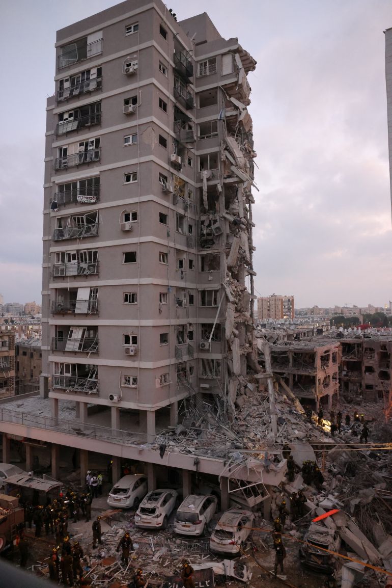 People stand near a residential building that was hit following missile attack from Iran on Israel, at central Israel June 15, 2025. REUTERS/Tomer Appelbaum ISRAEL OUT. NO COMMERCIAL OR EDITORIAL SALES IN ISRAEL