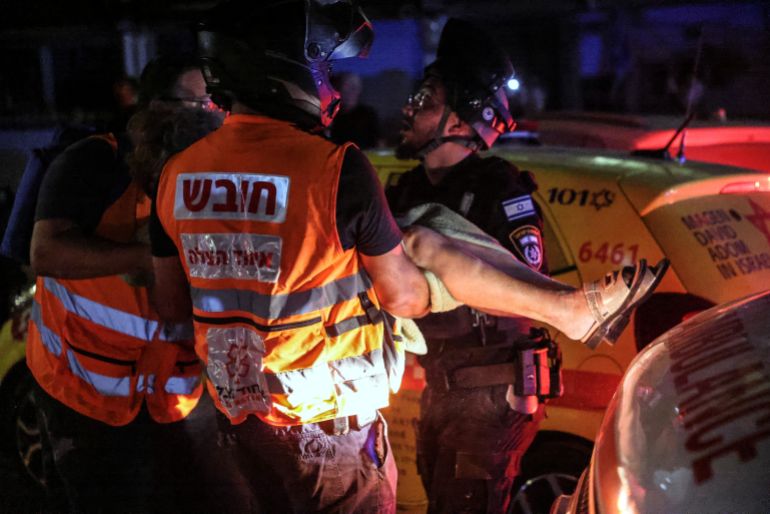 Rescue and medical personnel help an injured woman at an impact site following missile attack from Iran on Israel, at central Israel June 15, 2025. REUTERS/Tomer Appelbaum ISRAEL OUT. NO COMMERCIAL OR EDITORIAL SALES IN ISRAEL TPX IMAGES OF THE DAY