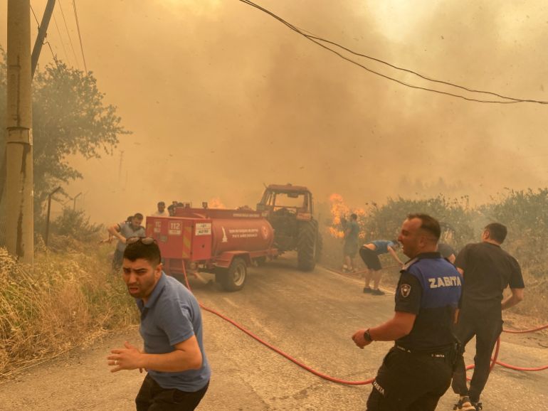Firefighters and local residents respond to a wildfire in Menderes district of the Aegean city of Izmir, Turkey, June 29, 2025. Ihlas News Agency (IHA) via REUTERS ATTENTION EDITORS - THIS PICTURE WAS PROVIDED BY A THIRD PARTY. NO RESALES. NO ARCHIVES. TURKEY OUT. NO COMMERCIAL OR EDITORIAL SALES IN TURKEY.