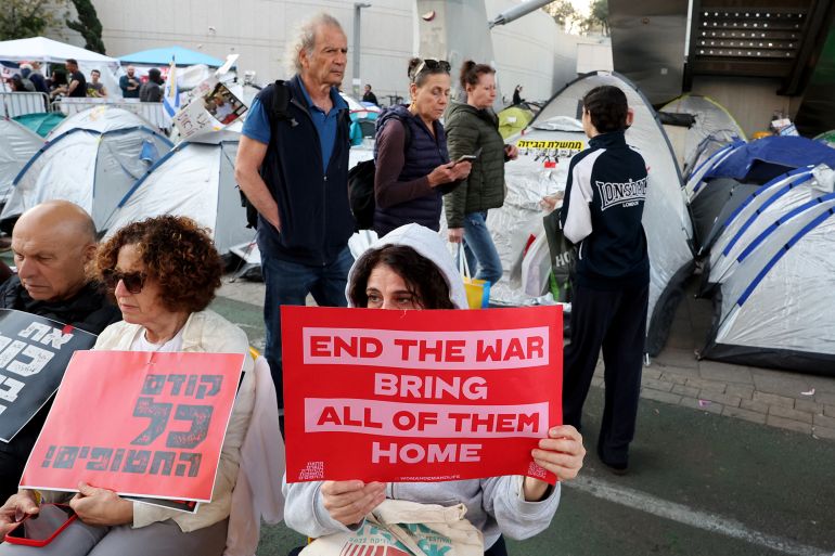People holds placards as friends and relatives of Israelis held hostage by Palestinian militants in Gaza since October 2023, set up tents around the Defence Ministry in Tel Aviv calling for action to secure their release on March 11, 2025. (Photo by Jack GUEZ / AFP)