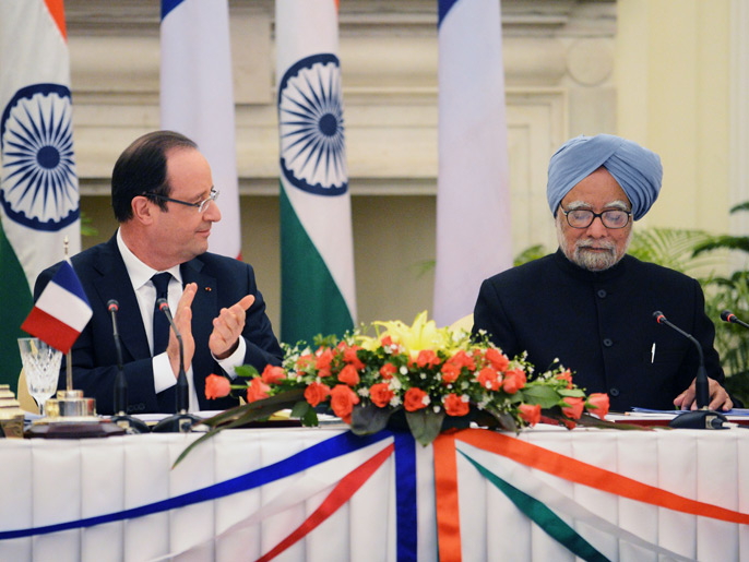 French President Francois Hollande (L) claps at the end of Indian Prime Minister Manmohan Singh's speech after members of their delegation signed several bilateral agreements in New Delhi on February 14, 2013. French President Francois Hollande embarked on a fresh push to clinch a USD 12-billion sale of Rafale fighter jets as he held talks in India on his first visit to Asia since taking office. The Socialist president was accompanied by a high-powered delegation of five ministers including Foreign Minister Laurent Fabius and Defence Minister Jean-Yves Le Drian and the chiefs of more than 60 top French companies