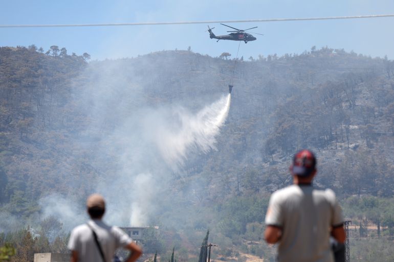 A Turkish helicopter helps battle a forest fires in the coastal Syrian province of Latakia on July 5, 2025. Syrian emergency workers were battling forest fires raging in the coastal province of Latakia on Saturday for a third day in tough conditions as neighbouring Turkey sent assistance. Syria's ministry for emergencies and disaster management said teams from Turkey began helping on Saturday morning "as part of regional coordination to face the fires", with the assistance including two aircrafts and eight fire trucks. (Photo by OMAR HAJ KADOUR / AFP)