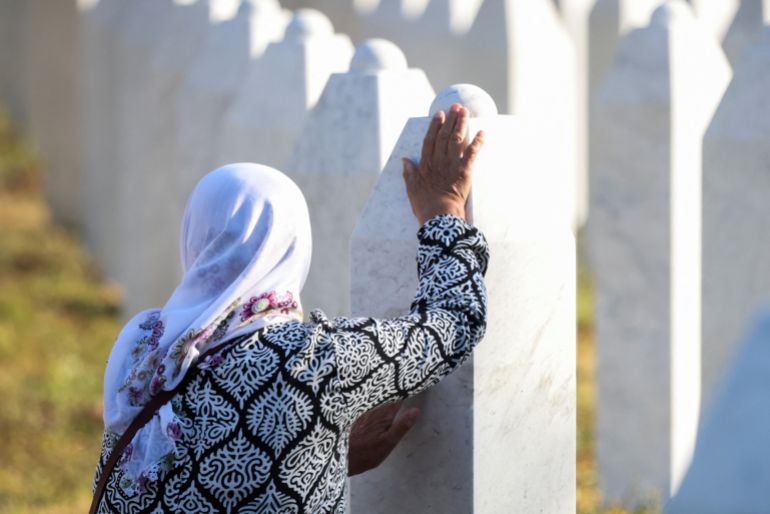 A Bosnian Muslim woman reacts as she stands amid grave stones of victims killed during the Srebrenica genocide, at the Srebrenica Genocide Memorial in Potocari, Bosnia and Herzegovina, July 11, 2025. REUTERS/Amel Emric