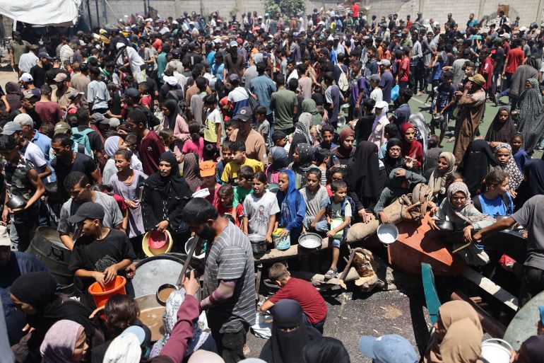 Palestinians gather at a food distribution point in the Nuseirat refugee camp in the central Gaza Strip on July 19, 2025.
