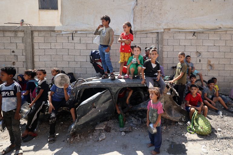 Palestinians children wait at a food distribution point in the Nuseirat refugee camp in the central Gaza Strip on July 19, 2025.