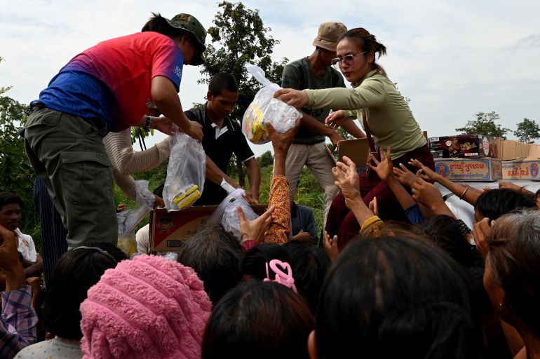 People who fled their homes near the border between Cambodia and Thailand, gather to get some food at a pagoda in Oddar Meanchey province on July 26, 2025.