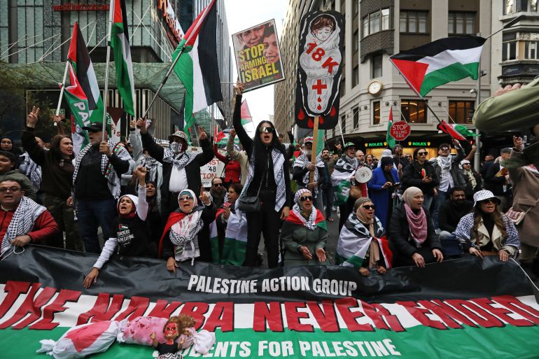 SYDNEY, AUSTRALIA - JULY 13: Demonstrators chant and wave flags and placards during a rally for Gaza on July 13, 2025 in Sydney, Australia. Demonstrators displayed red fabric meters long through Hyde Park to symbolise a 'red line of humanity' then proceeded to march through the central business district (CBD). They are calling for an end to the violence in Gaza and challenge the NSW Minns Labor Government anti-protest laws. (Photo by Lisa Maree Williams/Getty Images)