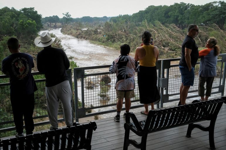 People look at the Guadalupe river, following flash flooding, as they gather after receiving a SMS alerting on potential floods in the area, in Kerrville, Texas, U.S. July 6, 2025. REUTERS/Marco Bello TPX IMAGES OF THE DAY