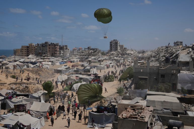 Palestinians rush to collect humanitarian aid airdropped by parachutes into Gaza City, northern Gaza Strip, Aug. 7, 2025. (AP Photo/Jehad Alshrafi)