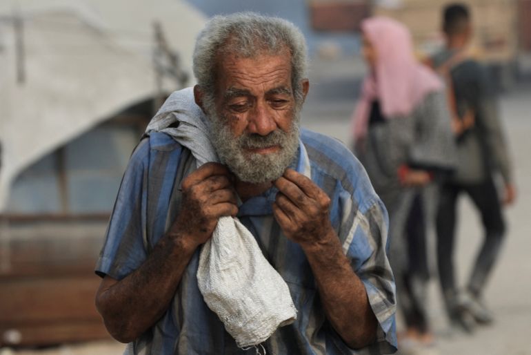A palestinian man carries aid supplies he collected from trucks that entered Gaza through Israel, in Beit Lahia, in the northern Gaza Strip August 10, 2025. REUTERS/Dawoud Abu Alkas