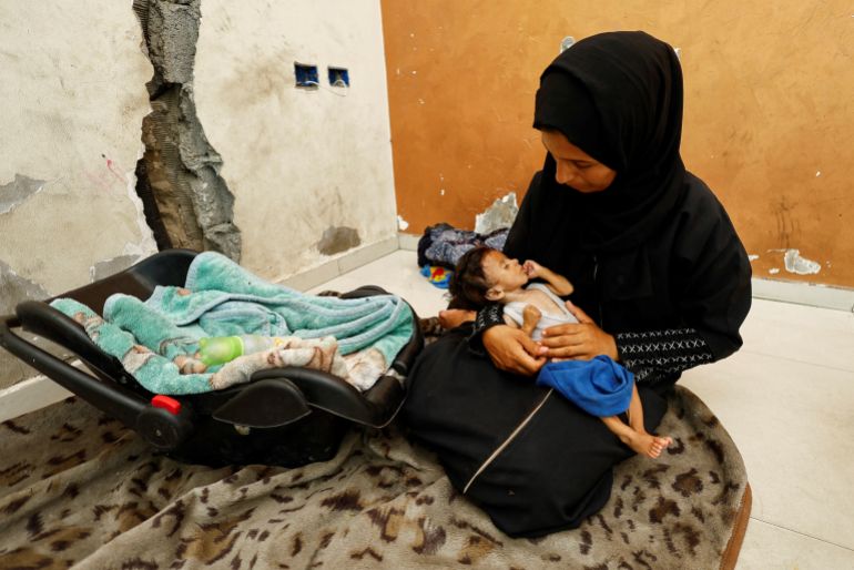 Palestinian mother Amira Muteir holds her five-month-old baby Ammar, whom she says is wasting away from malnutrition, in Gaza City, August 5, 2025. REUTERS/Mahmoud Issa