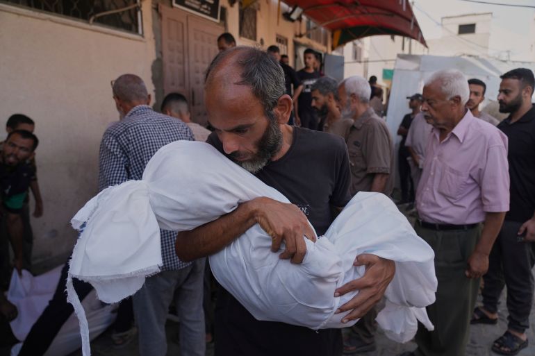 Ahmed Al-Hajj carries the body of his daughter, Dana Al-Hajj, 13, who was killed in an Israeli airstrike in the Gaza Strip, at Al-Aqsa Hospital in Deir al-Balah, Tuesday, Aug. 19, 2025. (AP Photo/Abdel Kareem Hana)