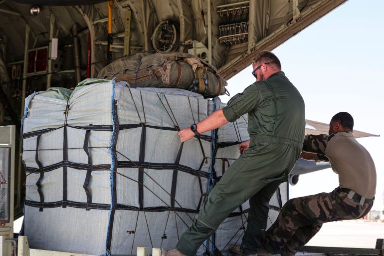 Members of the French Air Force, load the C-130 plane with humanitarian aid containers which will be airdropped to Palestinians in the Gaza Strip, Friday, Aug. 8, 2025. (AP Photo/Raad Adayleh)