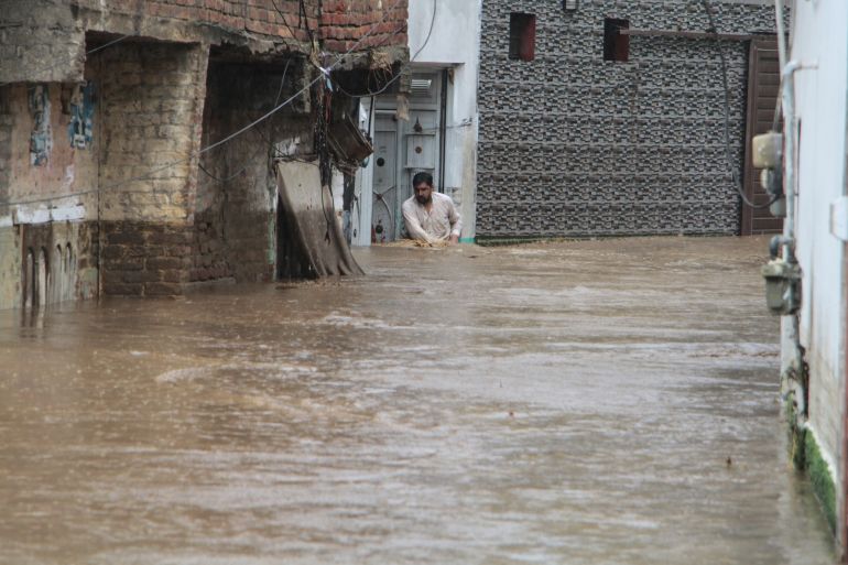 A resident navigates through a flooded street following flash flooding due to heavy rains at a neighbourhood of Mingora, the main town of Swat Valley, northwestern Pakistan, Friday, Aug. 15, 2025. (AP Photo/Naveed Ali)