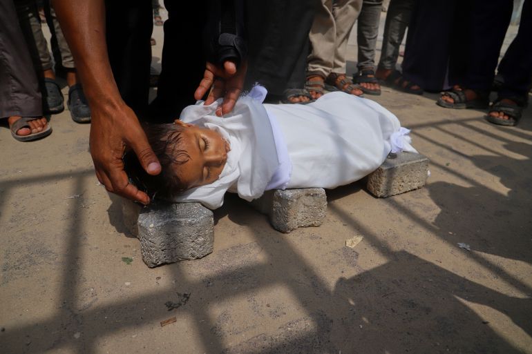FILE - The body of 5-year-old Jamal al-Najjar is placed on the ground atop bricks before a funeral prayer after he died at Nasser Hospital in Khan Younis, southern Gaza Strip, Tuesday, Aug. 12, 2025. The head of Nasser's pediatrics unit said Jamal, who was born with rickets, died from severe malnutrition. (AP Photo/Mariam Dagga, File)