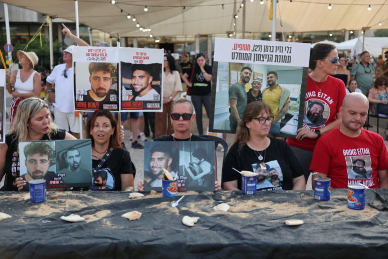epa12291234 Families of Israeli hostages held by Hamas in Gaza sit at a diner table with canned beans and a piece of bread during calling the government to sign a hostages release and ceasefire deal, outside the Kirya military headquarters in Tel Aviv, Israel, 09 August 2025. According to the Israeli army (IDF) spokesperson, around 50 Israeli hostages remain in captivity in the Gaza Strip, including the bodies of at least 30 confirmed dead. EPA/ABIR SULTAN
