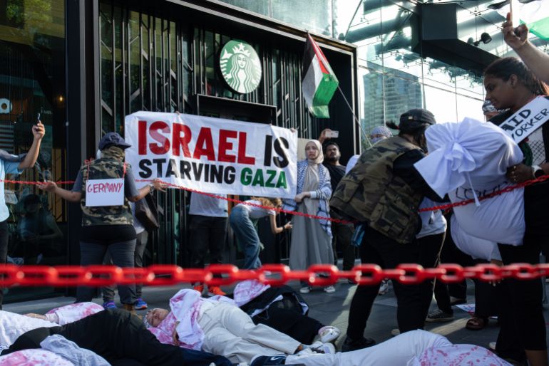 KUALA LUMPUR, MALAYSIA – AUGUST 02: Pro-Palestinian protesters perform a protest in front of a Starbucks, highlighting the ongoing crisis in Gaza during a march to express solidarity with the people of Palestine on August 2, 2025 in Kuala Lumpur, Malaysia. Protesters in Malaysia joined marches and actions globally, as pressure mounts on the Israeli government over a devastating humanitarian crisis unfolding as its war against Hamas continues. (Photo by Annice Lyn/Getty Images)