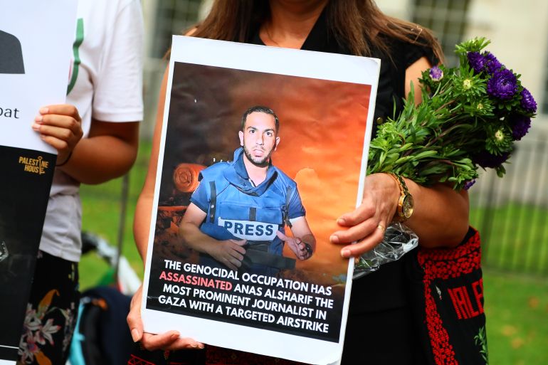 LONDON, ENGLAND - AUGUST 13: A woman holds a picture of journalist Anas al-Sharif as NUJ members hold a vigil outside Downing Street following the deaths of five Palestinian journalists working for Al Jazeera in Gaza, on August 13, 2025 in London, England. The National Union of Journalists London Chapter invited members to hold a vigil outside Downing Street for the 192 colleagues who are confirmed to have been killed in Gaza by Israeli military action. This comes after five Palestinian journalists working for Al Jazeera were killed by the IDF this week, including Anas al-Sharif. (Photo by Alishia Abodunde/Getty Images)