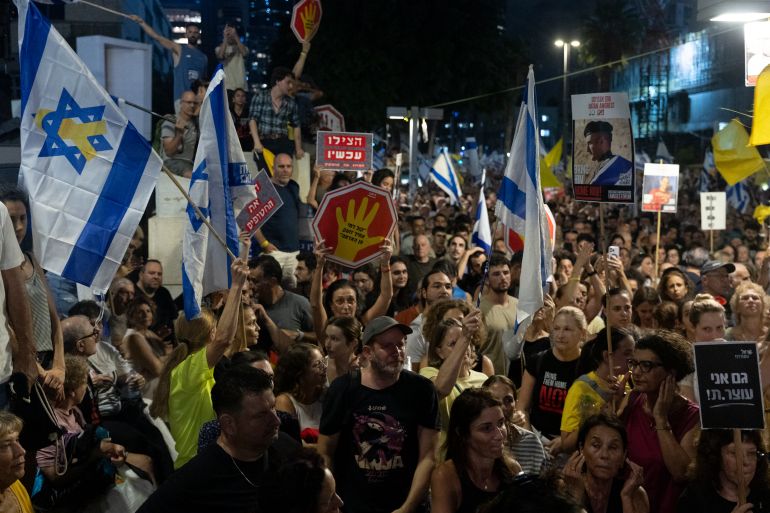 TEL AVIV, ISRAEL - AUGUST 17: Families of hostages and supporters holdflags and signs during a demonstration calling for an hostages deal on August 17, 2025 in Tel Aviv, Israel. Family members and supporters of hostages held captive by Hamas since the October 7, 2023 attacks have called for demonstrations and a nationwide labor strike in Israel on Sunday, to demand a ceasefire and return of the remaining hostages. Israeli Prime Minister Benjamin Netanyahu's plan to expand the IDF offensive in Gaza has been met with widespread condemnation by the international community, as well as hostage families, who say the move will further endanger the 20 or hostages still believed to be held alive by Hamas in Gaza, as well as one million Palestinians in Gaza City, who are already facing displacement and an acute hunger crisis. (Photo by Amir Levy/Getty Images)