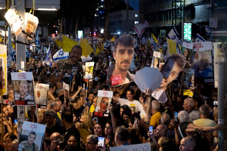 TEL AVIV, ISRAEL - AUGUST 17: Families of hostages and supporters holdflags and signs during a demonstration calling for an hostages deal on August 17, 2025 in Tel Aviv, Israel. Family members and supporters of hostages held captive by Hamas since the October 7, 2023 attacks have called for demonstrations and a nationwide labor strike in Israel on Sunday, to demand a ceasefire and return of the remaining hostages. Israeli Prime Minister Benjamin Netanyahu's plan to expand the IDF offensive in Gaza has been met with widespread condemnation by the international community, as well as hostage families, who say the move will further endanger the 20 or hostages still believed to be held alive by Hamas in Gaza, as well as one million Palestinians in Gaza City, who are already facing displacement and an acute hunger crisis. (Photo by Amir Levy/Getty Images)
