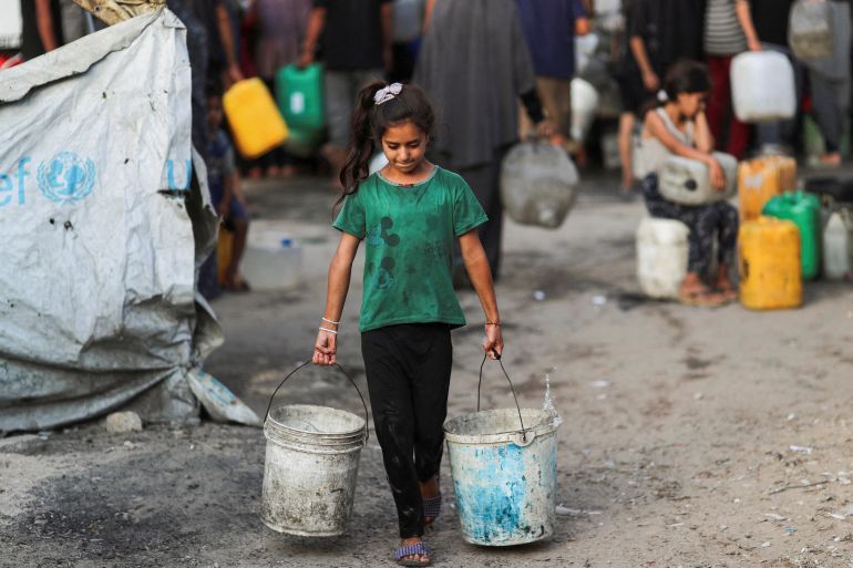 A Palestinian girl carries buckets of water amid shortages, in Gaza City August 6, 2025. REUTERS/Mahmoud Issa TPX IMAGES OF THE DAY
