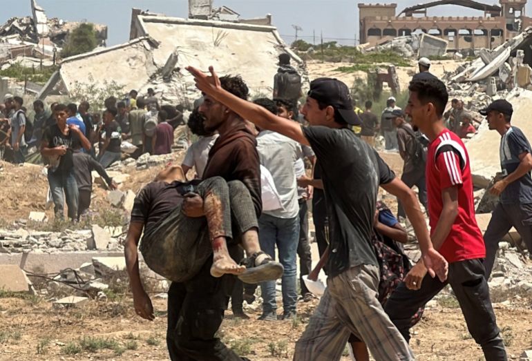 SENSITIVE MATERIAL. THIS IMAGE MAY OFFEND OR DISTURB A person carries the body of Palestinian boy Muhannad Eid, who died after being struck by a box of airdropped aid, in Nuseirat, in the central Gaza Strip, August 9, 2025. REUTERS/Stringer