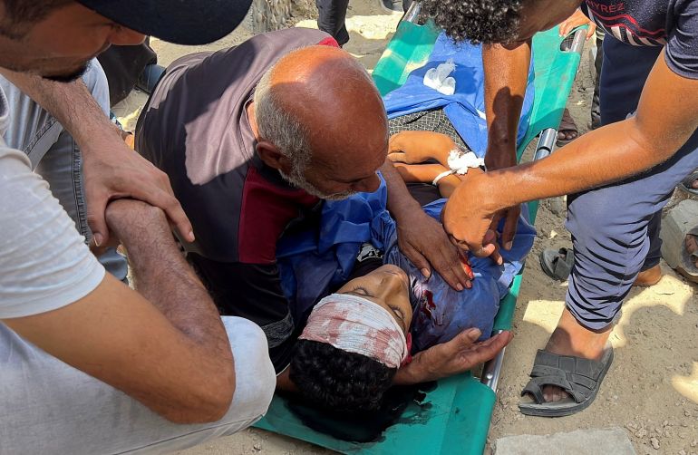 SENSITIVE MATERIAL. THIS IMAGE MAY OFFEND OR DISTURB The father of Palestinian boy Muhannad Eid, who died after being struck by a box of airdropped aid, places his hand on his son's chest during the funeral, in Nuseirat, in the central Gaza Strip, August 9, 2025. REUTERS/Stringer