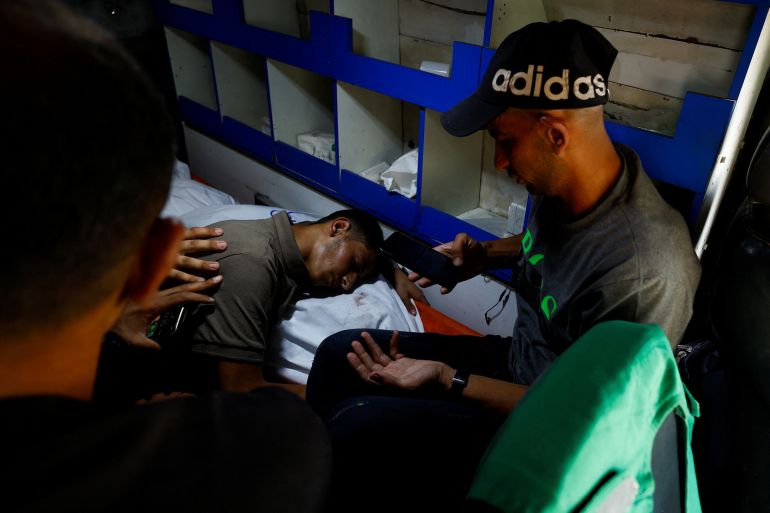Palestinians react next to the body of Al Jazeera journalist Anas Al Sharif, who was killed along with four colleagues in an Israeli airstrike, inside an ambulance in Gaza City August 11, 2025. REUTERS/Mahmoud Issa
