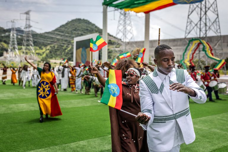 Performers wave Ethiopian flags and dance traditional songs during the official inauguration ceremony of the Grand Ethiopian Renaissance Dam (GERD) in Guba, on September 9, 2025.