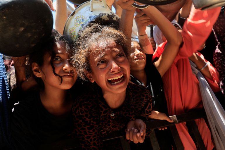 Palestinians wait to receive food from a charity kitchen, amid a hunger crisis, in Khan Younis, southern Gaza Strip, August 4, 2025. REUTERS/Hatem Khaled TPX IMAGES OF THE DAY