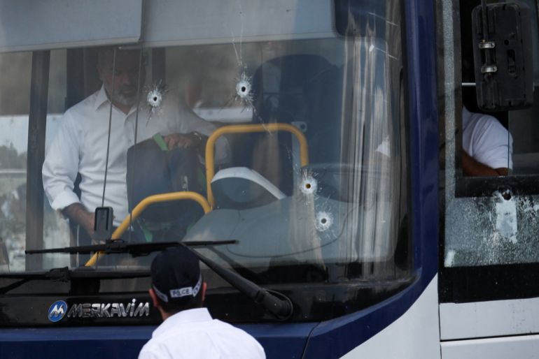 People inspect a bus with bullet holes in the windshield at the scene where a suspected shooting attack took place at the outskirts of Jerusalem, September 8, 2025 REUTERS/Ronen Zvulun