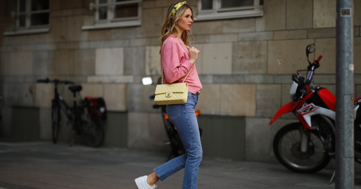 سكارليت جارتمان ترتدي سترة Vogue وردية اللون، وجينز Zara الأزرق، وعصابة رأس H&M صفراء، وحقيبة جلدية صفراء من شانيل، وأحذية رياضية بيضاء من شانيل في 24 مارس 2021 في دوسلدورف، ألمانيا.